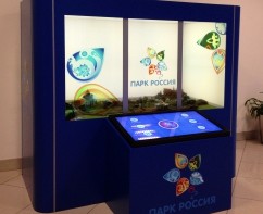 Интерактивный стенд «Парк Россия», три прозрачных ЖК-экрана, за которыми расположен макет парка. Cтойка с сенсорным экраном